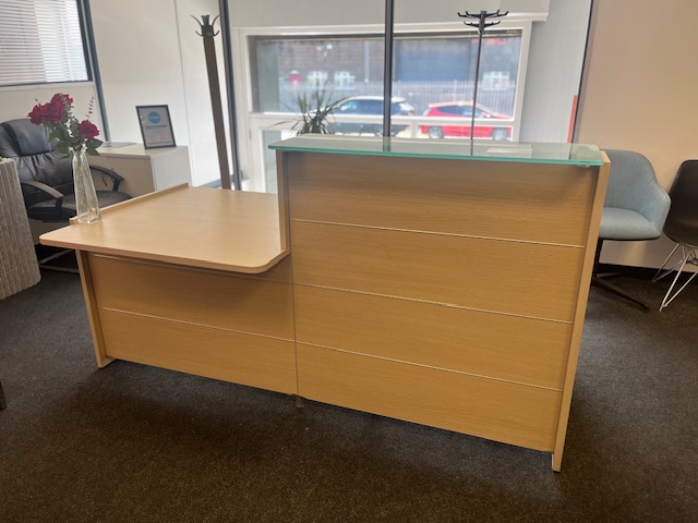 Light oak reception desk with frosted glass top screen.